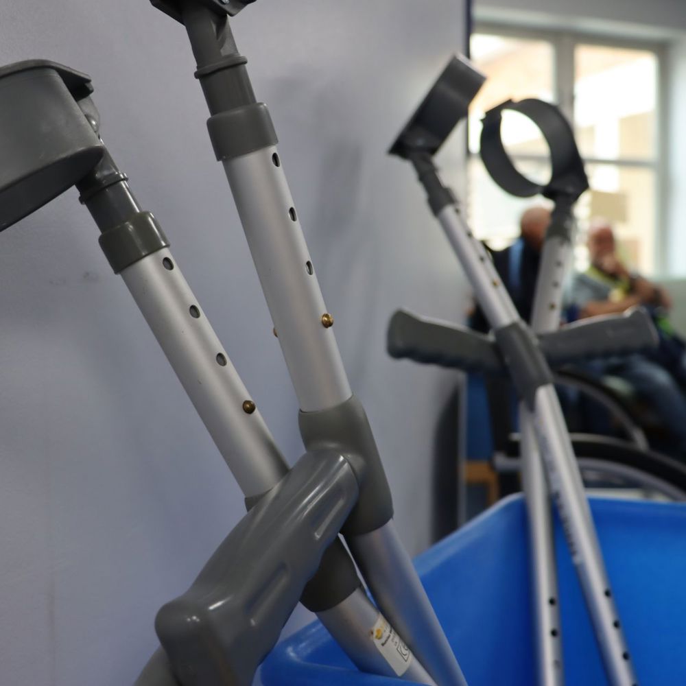 Several mobility crutches standing up in a blue box
